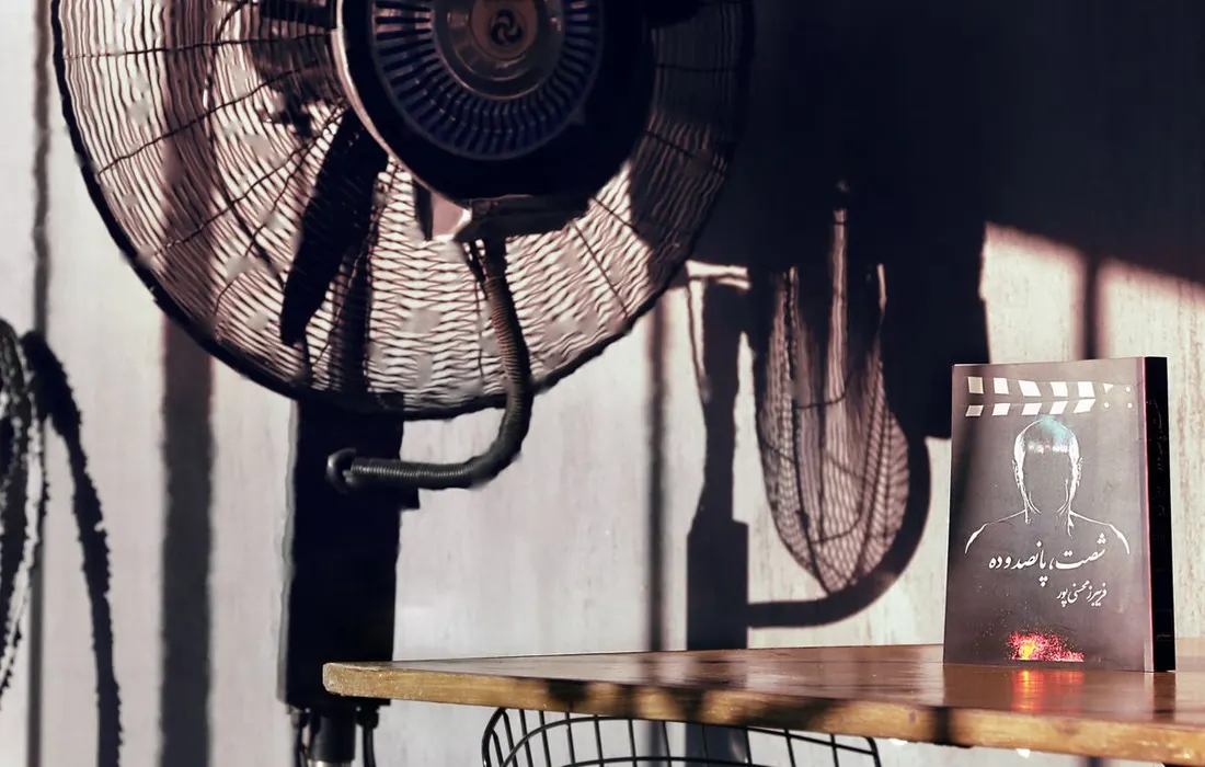 An electric fan and a book in a room.