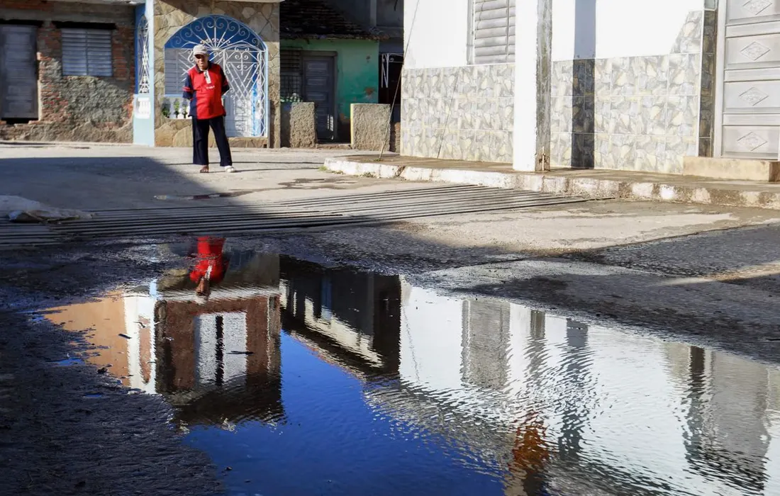 A city street with puddles creating reflections after rain, capturing urban life.