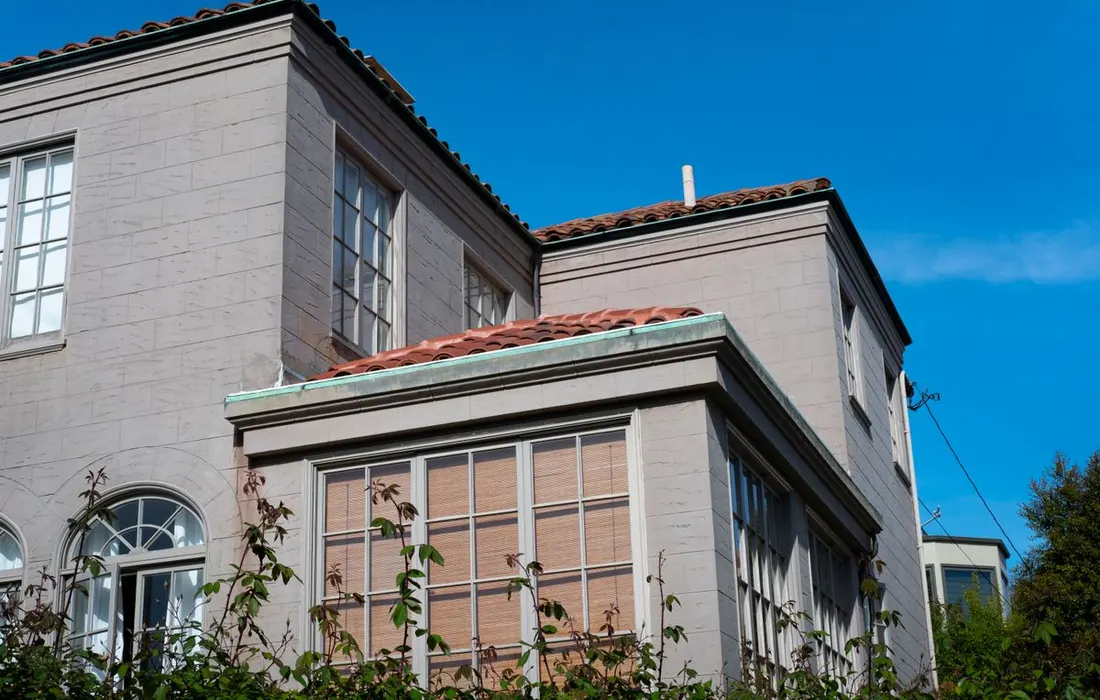 A house exterior and tiled roof viewed from ground level.