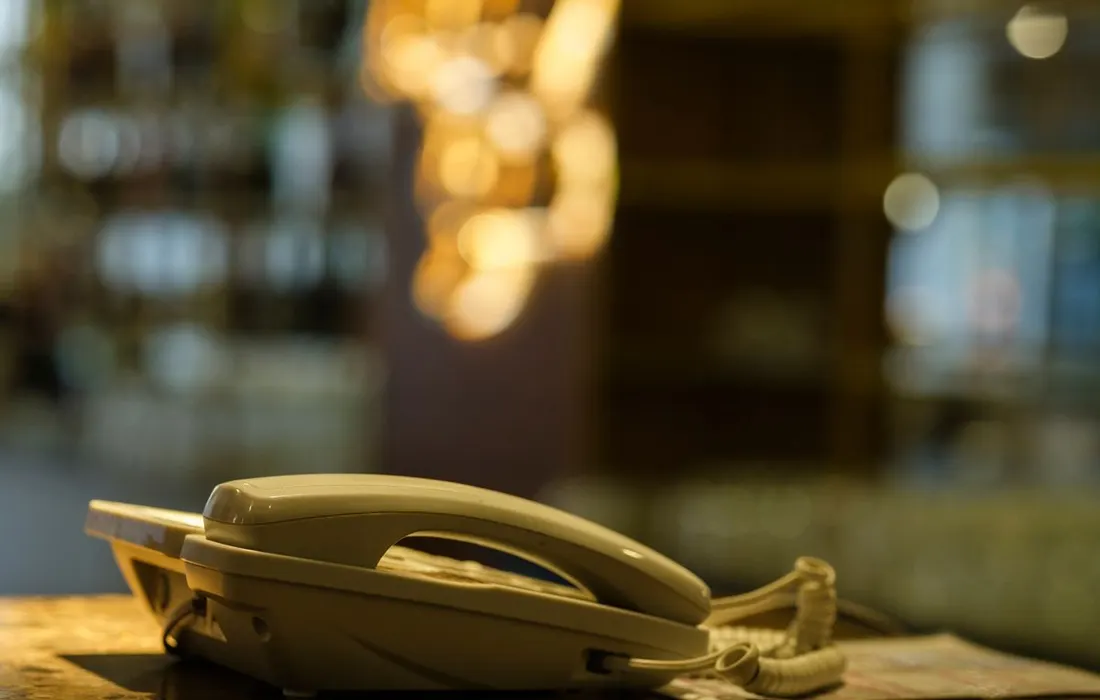 A landline telephone on a marble counter indoors.