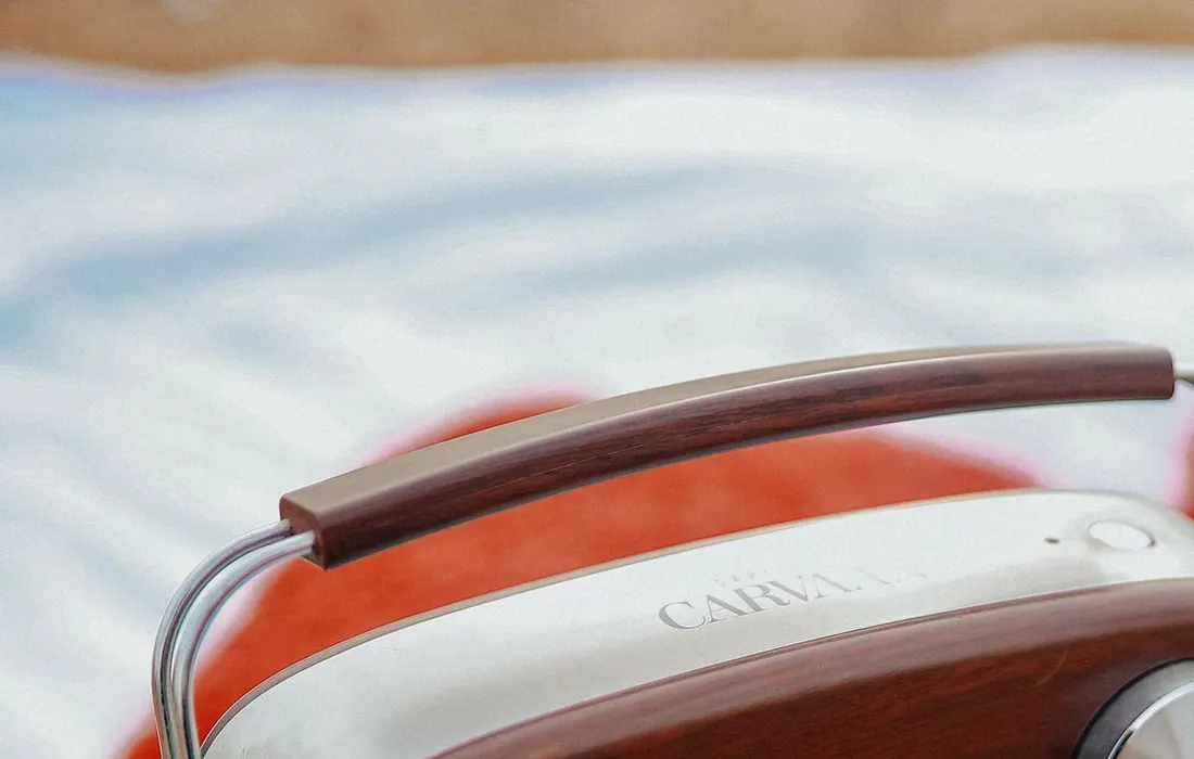 A vintage-style portable radio on an outdoor surface, illustrating radio listening.