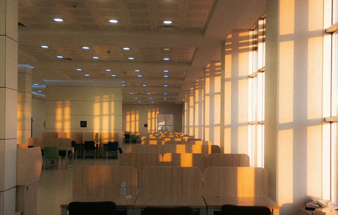 Tables and chairs in a sunlit hall.