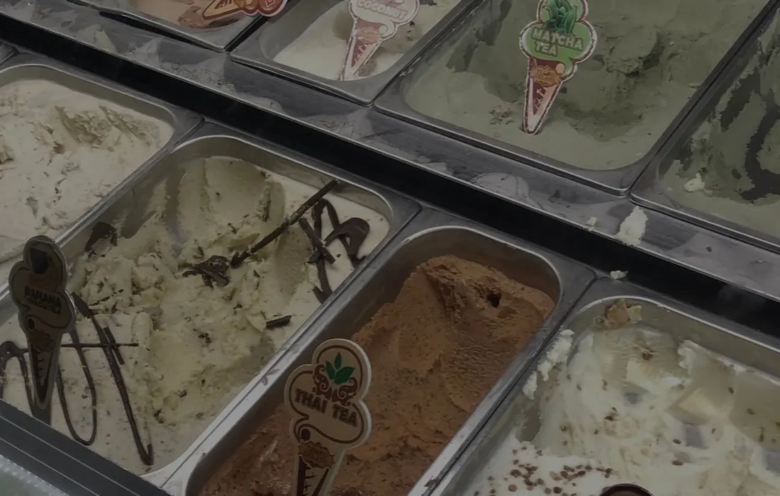Containers of ice cream arranged in a display freezer.