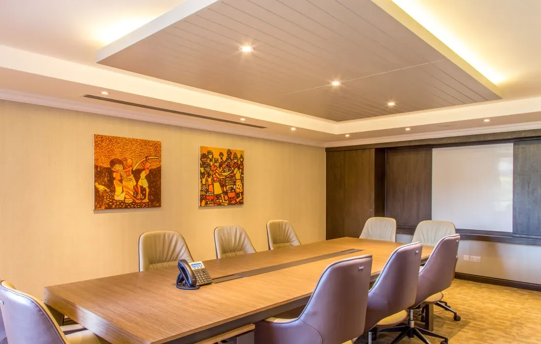 A meeting table and chairs beneath contemporary wall art.