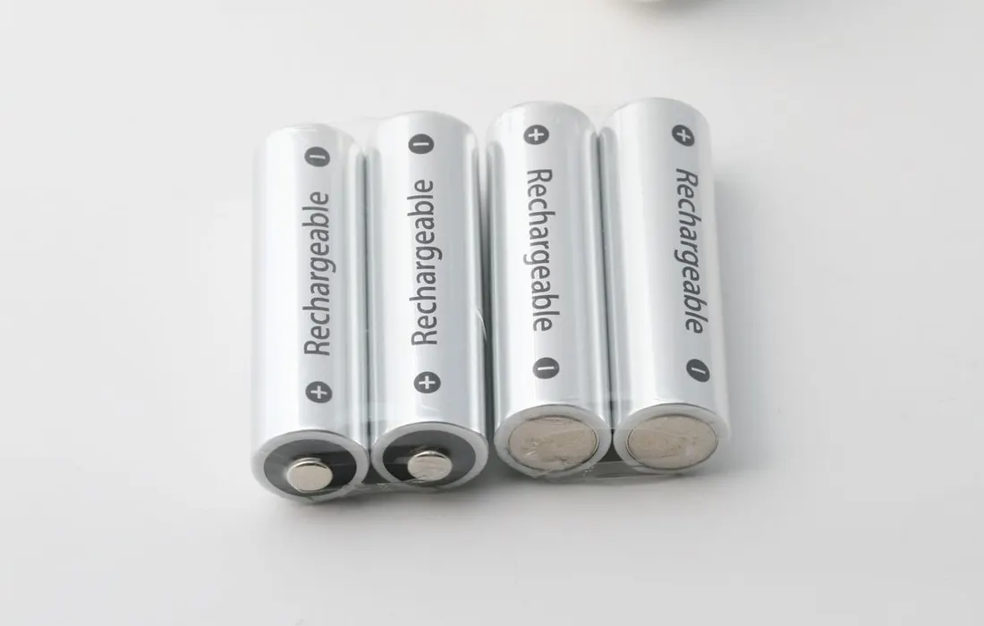Rechargeable batteries beside a battery charger.