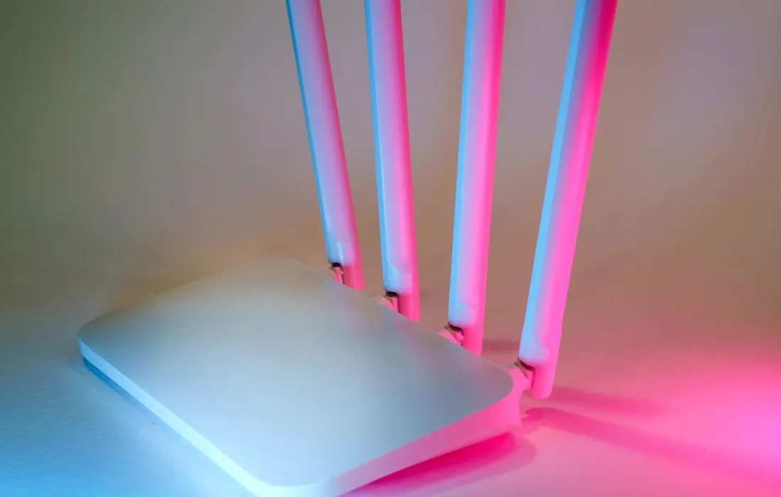 A home wireless router lit against a dark background.