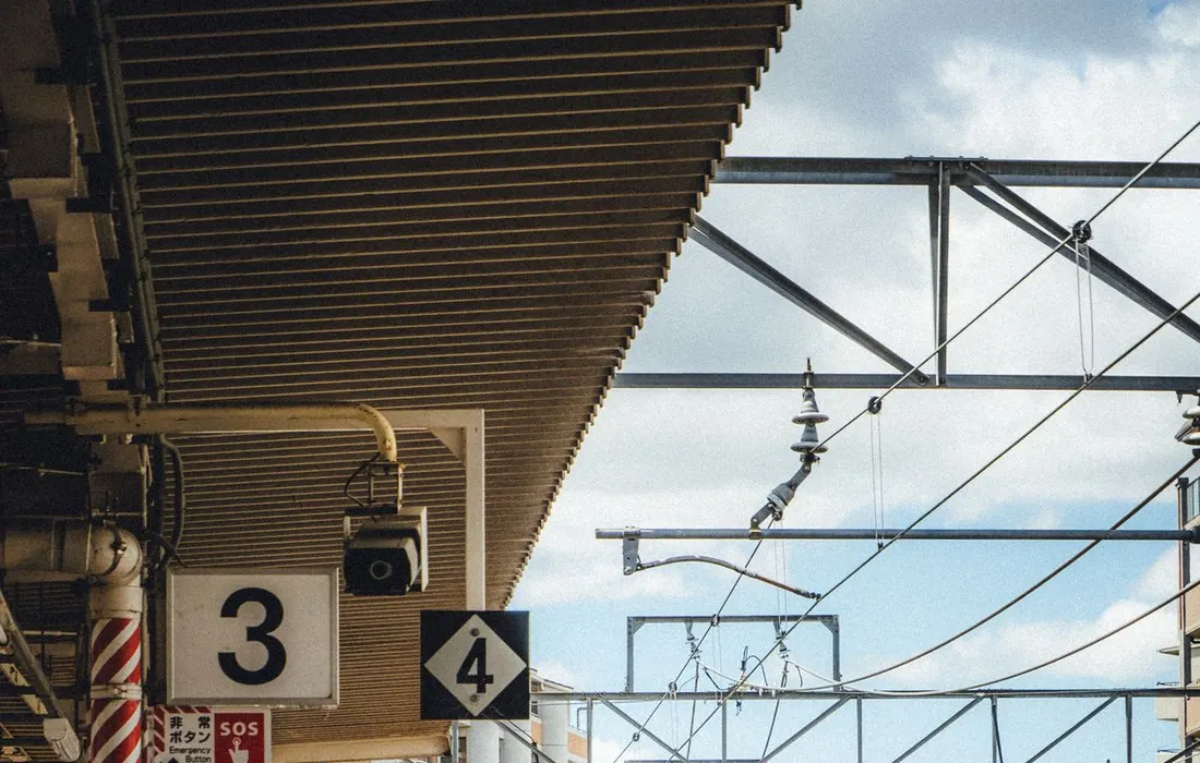 An unoccupied railway platform alongside tracks in daylight.