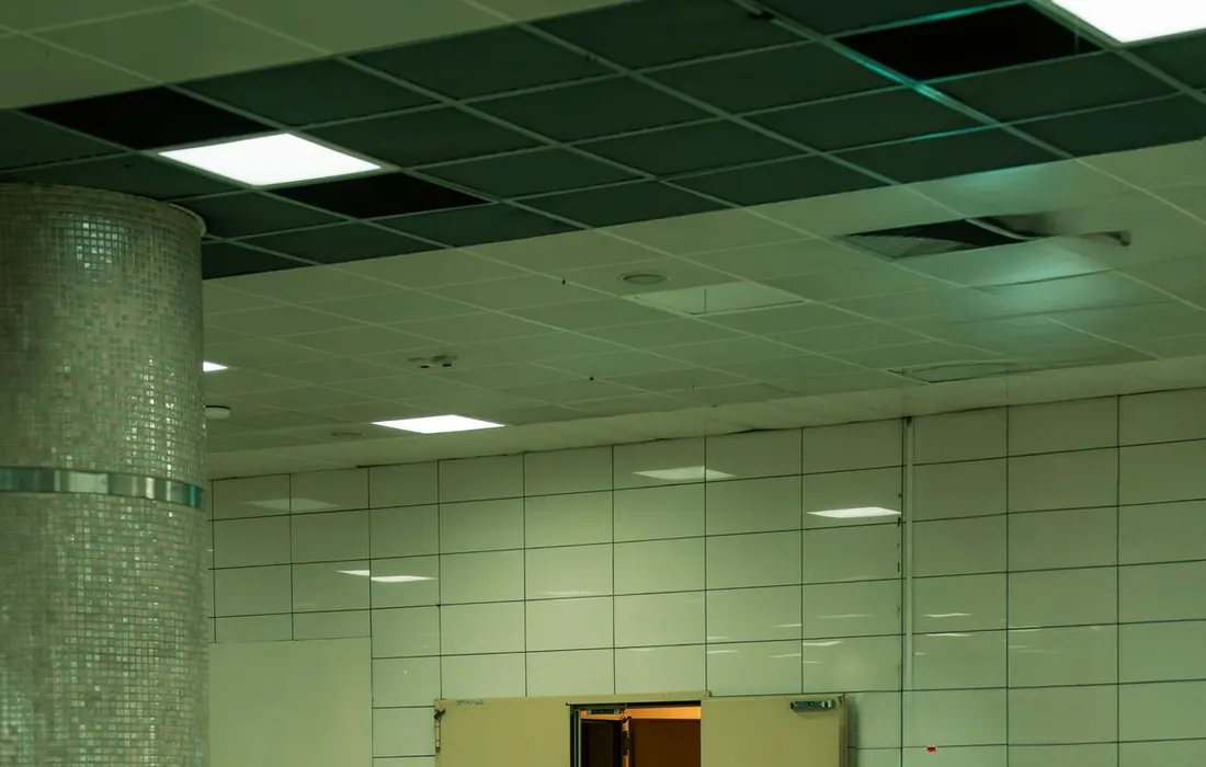 A clear indoor corridor leading to a signed emergency exit.