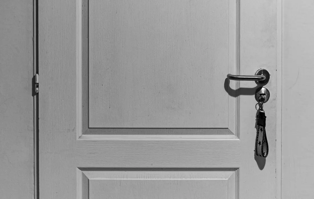 A key in a door lock, photographed in black and white.