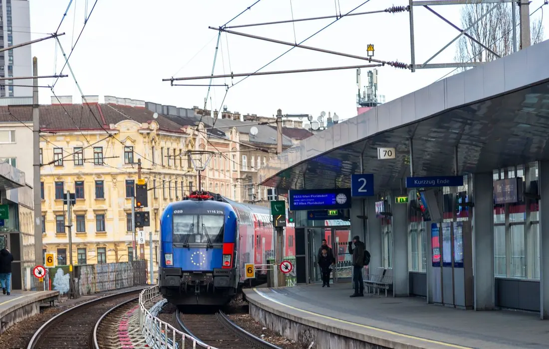A train arriving at an urban railway platform.