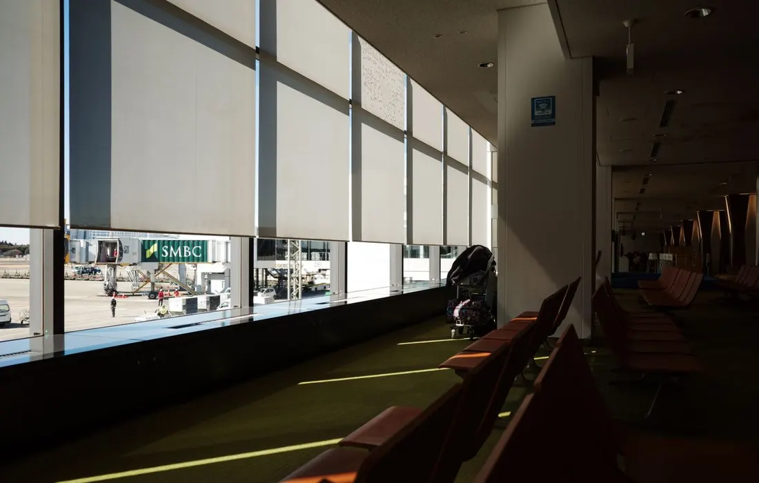 Rows of empty seats in a sunlit airport terminal.