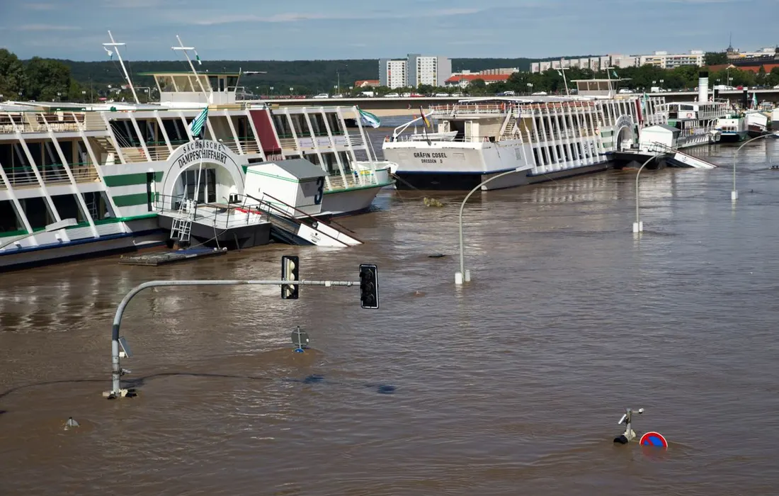 Street flooded with water as boats are partially submerged after heavy rain.