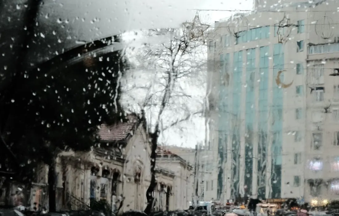 An urban street seen through a wet window.