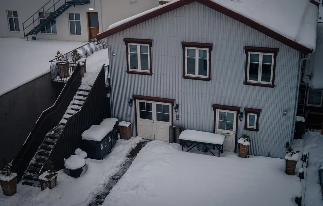 Snowy exterior of a house during winter, showcasing a serene landscape.
