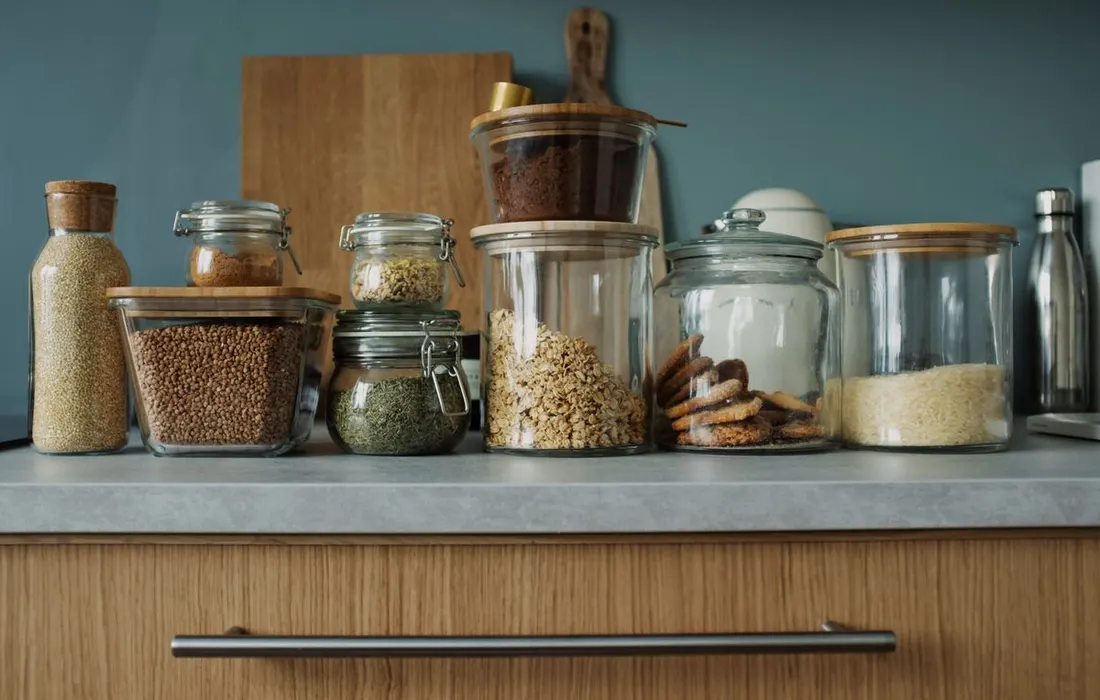 Glass storage jars arranged along a kitchen counter.