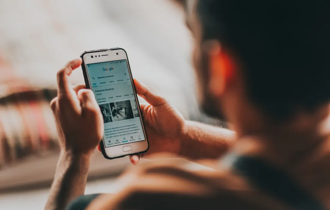A person reading information on a smartphone at home.