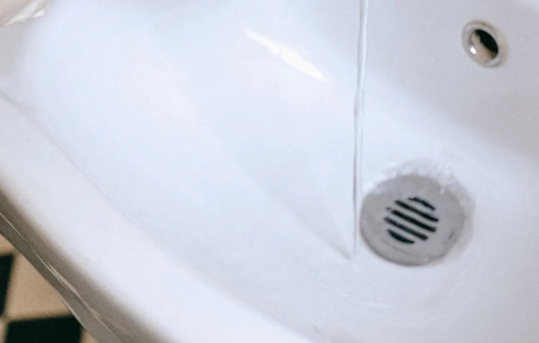 Hands being washed with soap under running water.