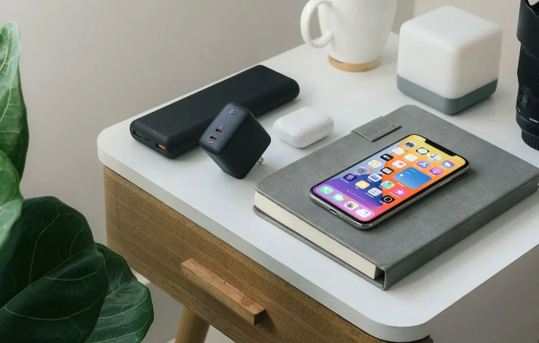 A smartphone beside a notebook, mug and desk accessories.