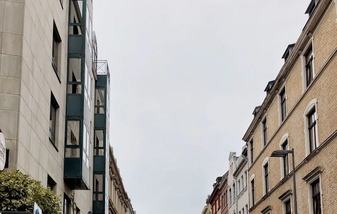 Pedestrians and historic buildings on a Cologne street.
