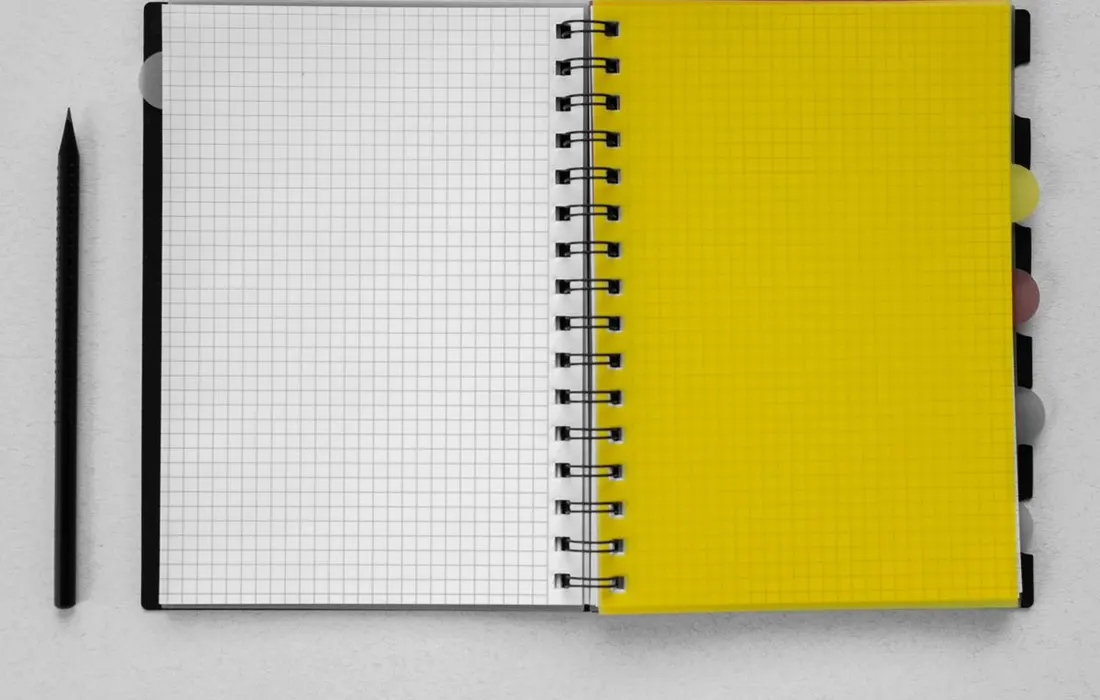 An open graph-paper notebook and a pencil.