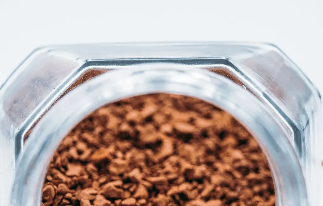 A glass jar of freeze-dried instant coffee granules.