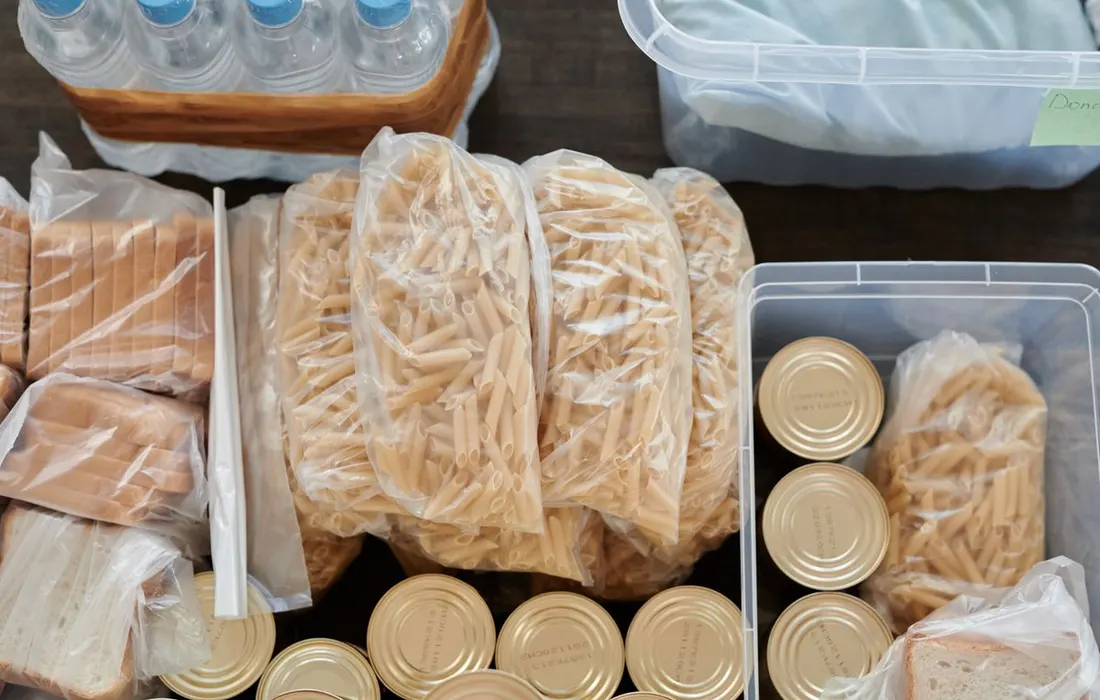 Pasta, tinned foods and bread arranged as pantry supplies.