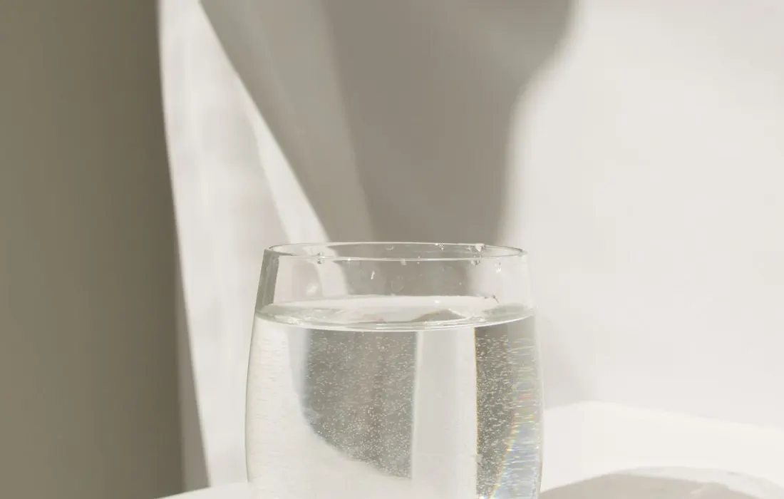 A glass of water on a white surface.
