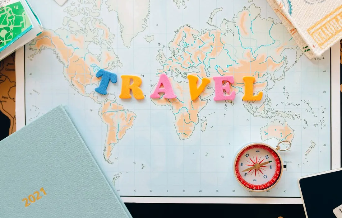 A paper map and compass arranged for travel planning.