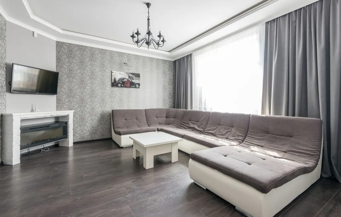A furnished living room with a sectional sofa and open floor space.