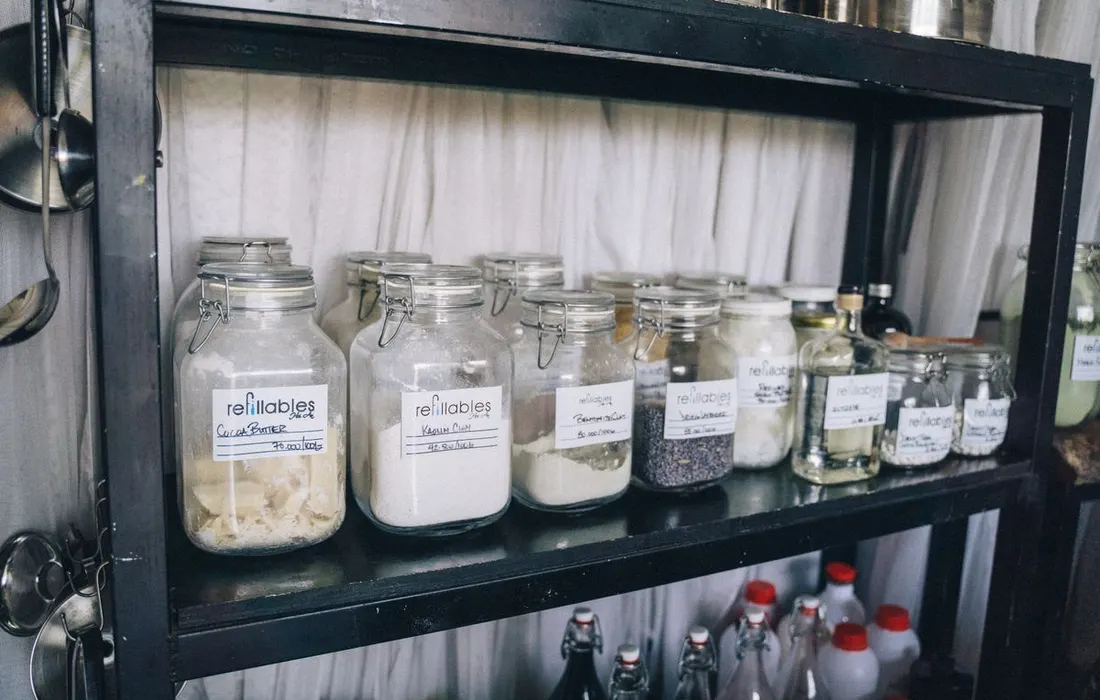 Glass food-storage jars arranged on a dark shelf.