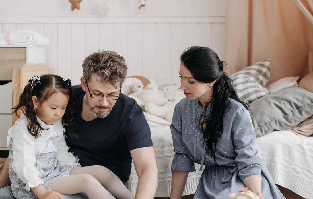A family gathered around a board game in a living room.