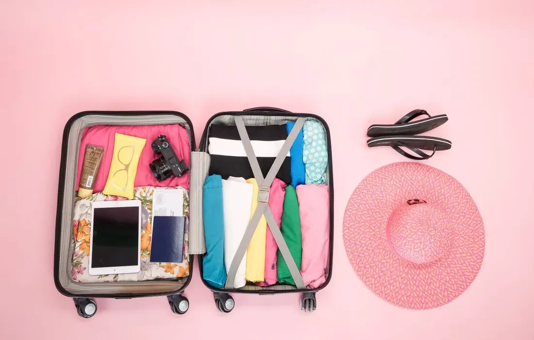 An open suitcase containing folded clothing and travel essentials.
