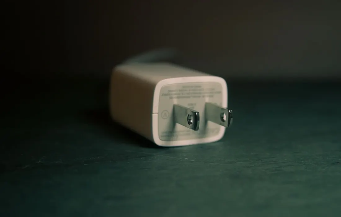 A white electrical travel adaptor indoors.