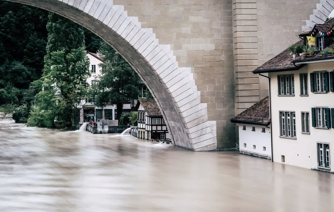A powerful flood fills the riverbank near an iconic arch bridge in Bern, Switzerland.