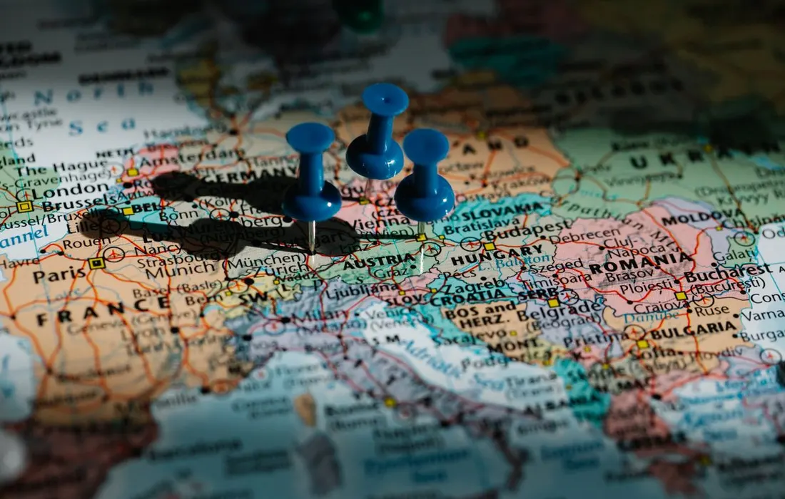 Blue pushpins marking places on a map of Europe.
