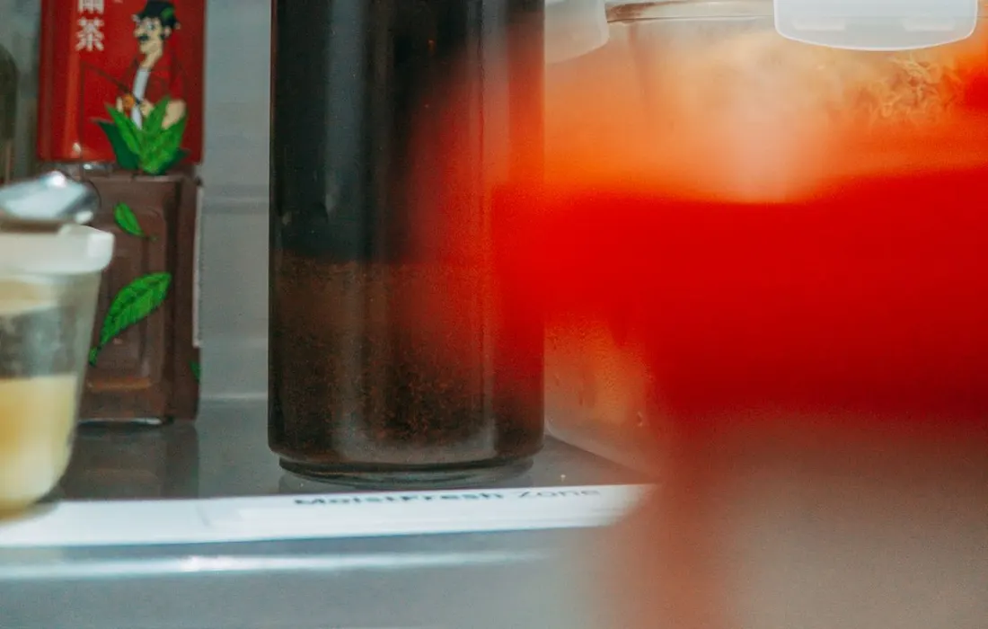 Food and drinks arranged on refrigerator shelves.