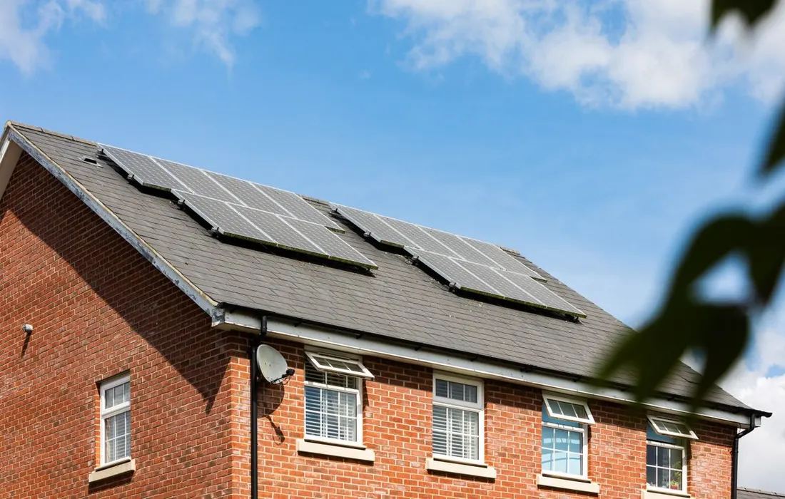 Solar panels installed on the roof of a brick house.