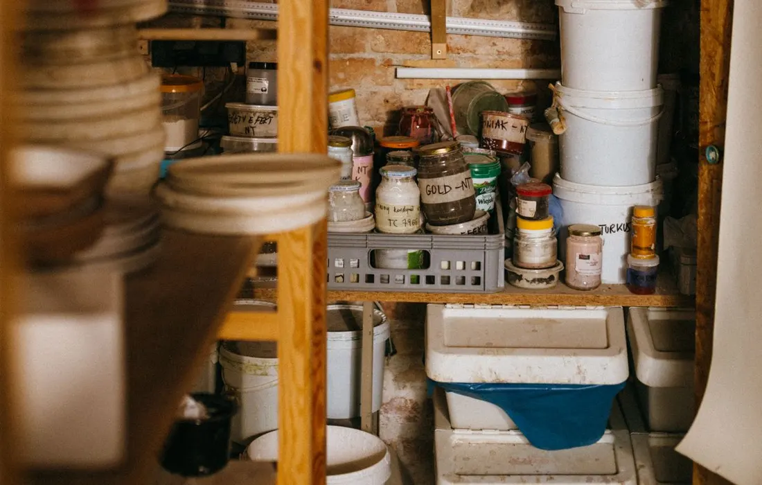 Wooden shelving holding containers and household supplies.